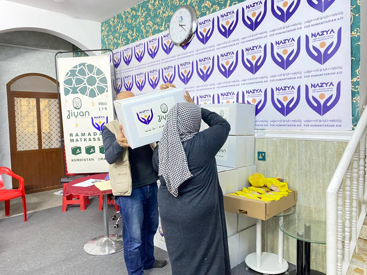 Nazya Organization distributing Ramadhan food baskets containing rice, oil, dates, and essential goods to families in Kurdistan